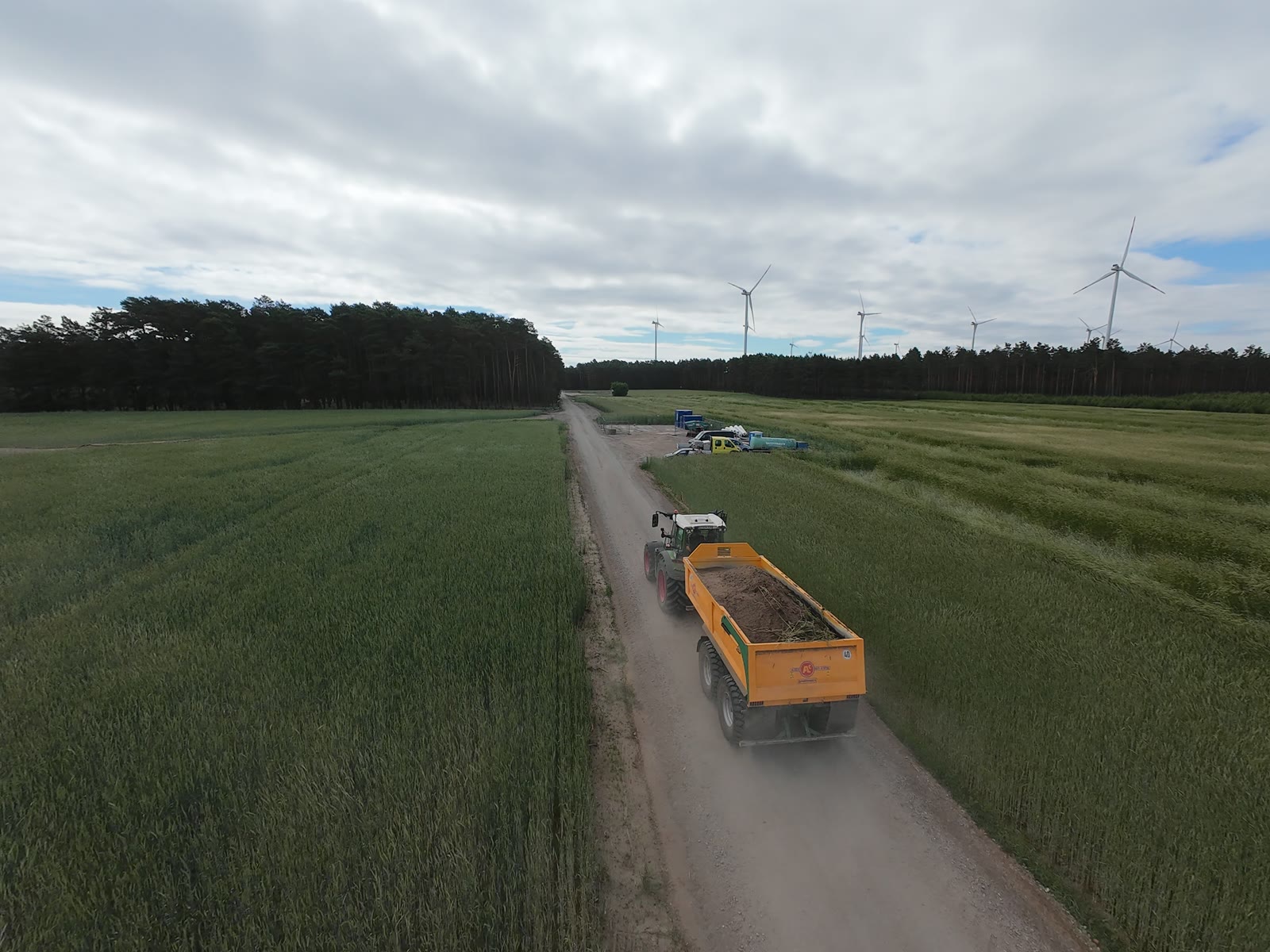 Traktor mit Kipper auf Baustraße vor Windpark